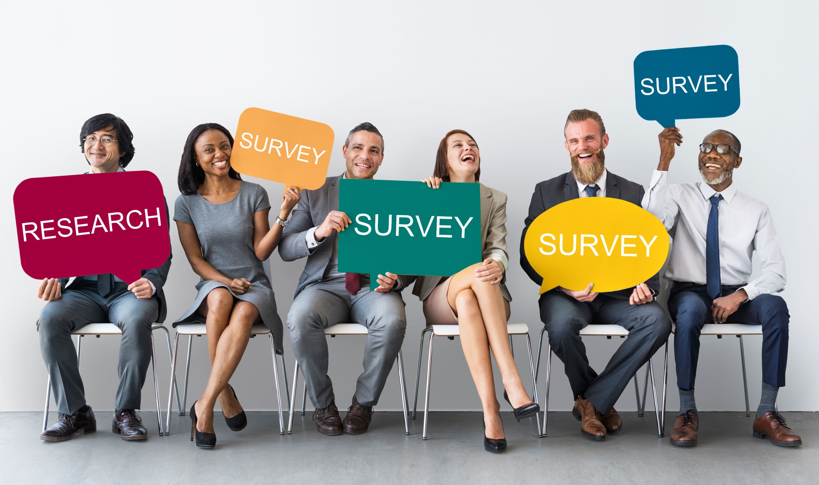 A diverse group of people holding billboards with surveys written in them.